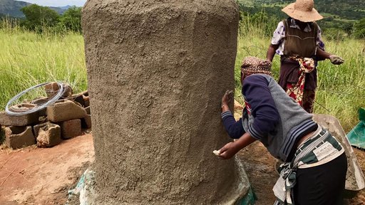 Women spreading cement to make the structure.