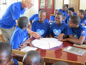 Volunteer David helps girls design on a healthy plateIMG_4478.JPG