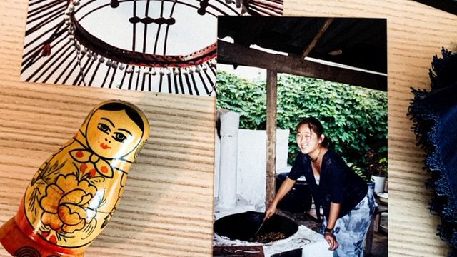 A picture of a picture of an Asian American Volunteer bending over a basket outside to work..