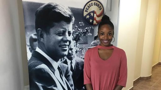 A Jamaican American Posing in Front of a John F. Kennedy Swearing-In Ceremony Sign