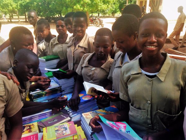 Girls receiving books from the "Books for Benin" project.