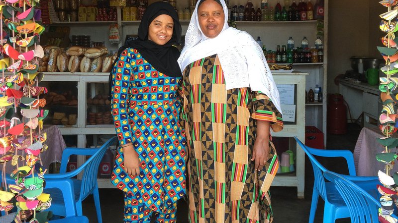 Jamila and Tata stand in their shop side by side for a photo
