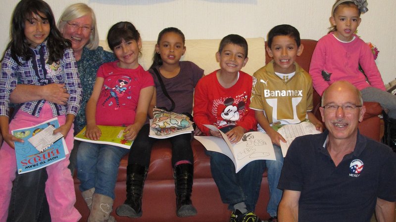 Mary and John engage children with coloring books about plants and wildlife.