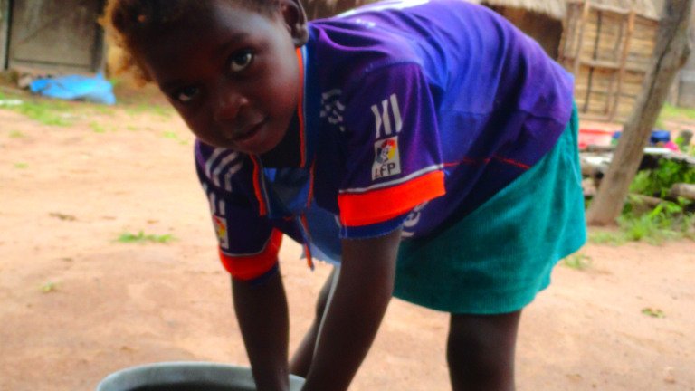 Muhlado cleaning the pot after lunch.