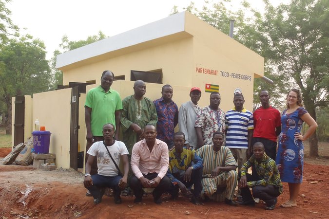 Togo: Community members pose with a Volunteer in front of the new latrines.