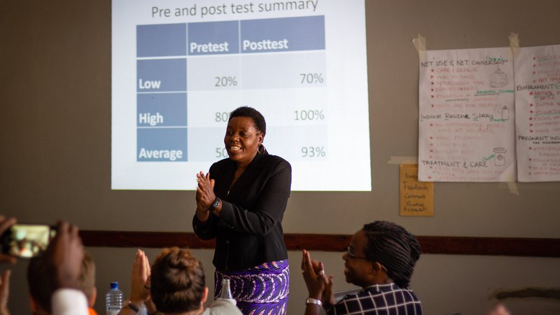 The trainer stands in front of the room engaging participants with activities.