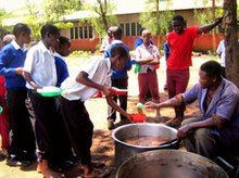 Boloti Secondary cook, Peter, served beans with vegetables harvested by PermaGarden members