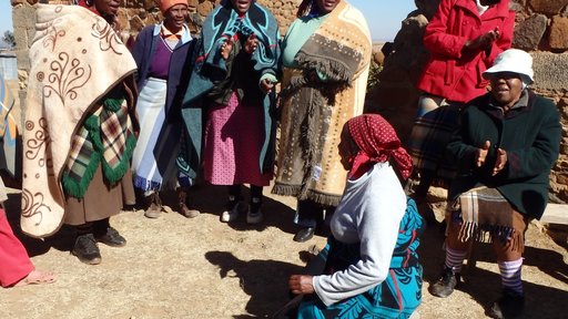 Women wearing all types of blankets for a community meeting..