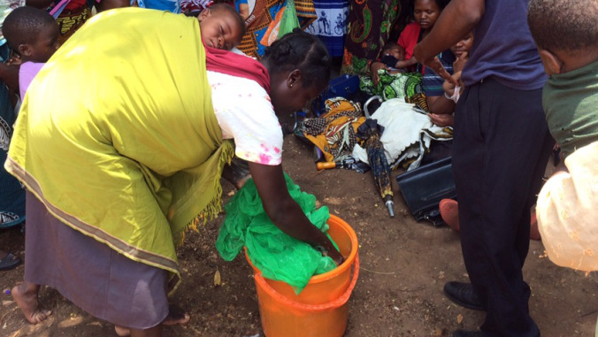 A Malawian community member washes her bednet at a demonstration by her Volunteer.