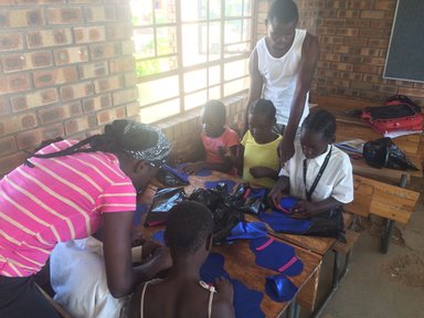 Child & youthcare workers help girls make RUMPs (reusable menstrual pads).