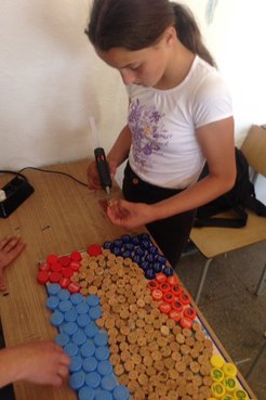Making a mural with bottle caps.
