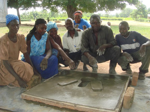 Uganda: Volunteer health team with the completed cement pit latrine.