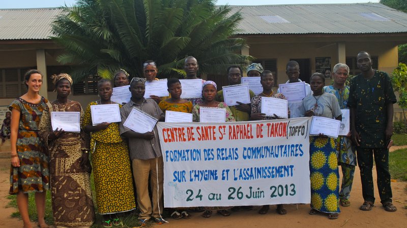 Returned Peace Corps Volunteer Rachel Leeds poses with a group of community health worker in Benin, following the completion