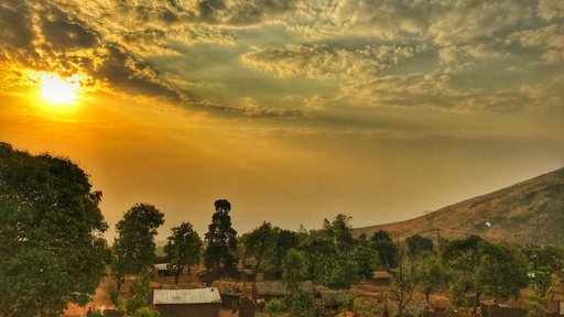 A colorful shot of a Volunteer's village in Malawi. The village is surrounded by trees and mountains.